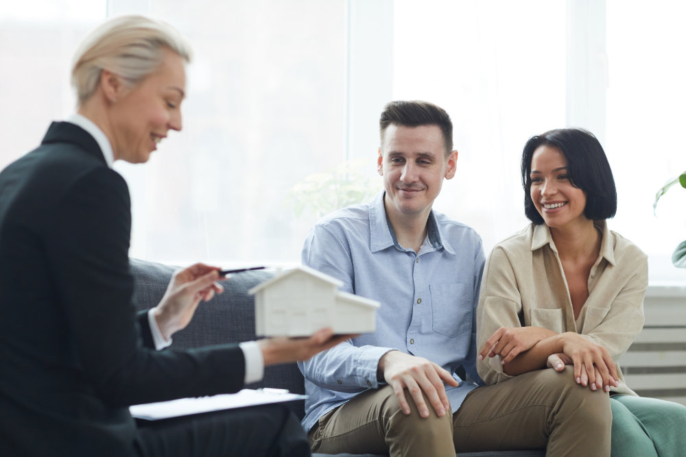 Young couple are going to buy the house Happy young couple listening to their real estate agent who telling about the house